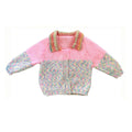 Knitted pink jacket with multicolored collar on a white background